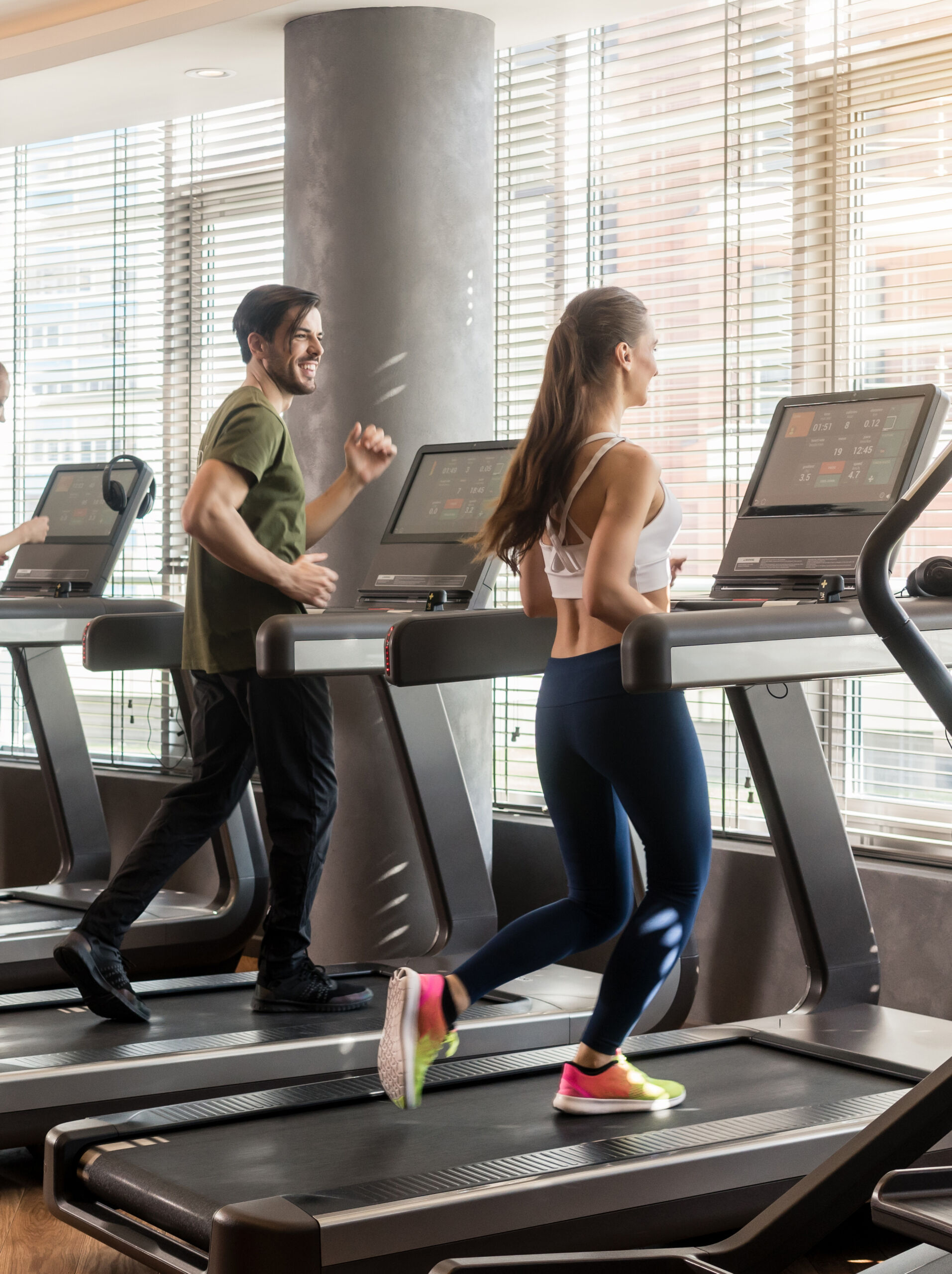 Two people on treadmills at the gym
