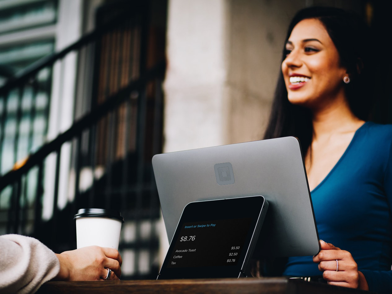 Woman smiling, sat behind a laptop